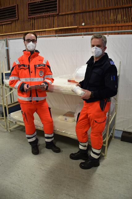 Die Zugführer der Johanniter, Tobias Könecke (li.) und Christian Klinke, richteten die Betten in der Schützenhalle ein | Foto: Johanniter