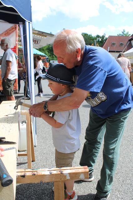 Werner Lührs vom Dorfverein half Paul Mats (4), einen Nagel einzuschlagen