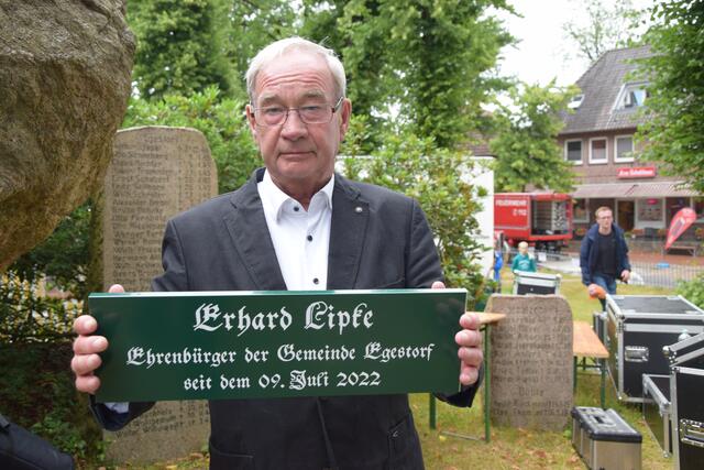 Erhard Lipke zeigt sein Ehrenbürger-Schild, das unter dem Straßenschild seiner Wohnstraße angebracht wird | Foto: ts
