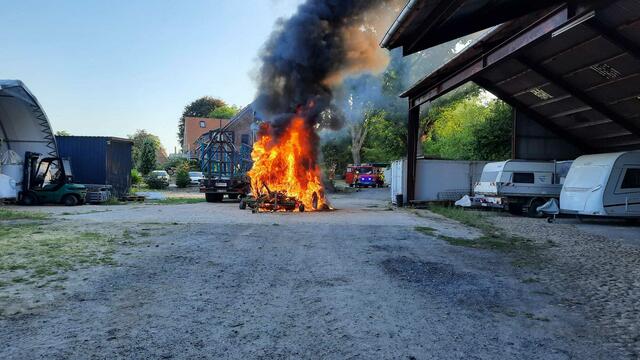 Eine Strohballenpresse brennt auf einem Hof in Ramelsloh | Foto: Feuerwehr Ramelsloh