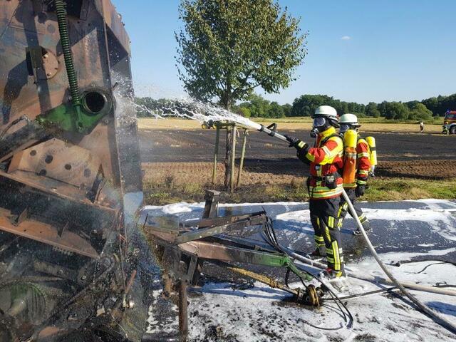 Feuerwehrleute löschen bei Lindhorst eine in Brand geratene Strohballenpresse  | Foto: A. Feldtmann