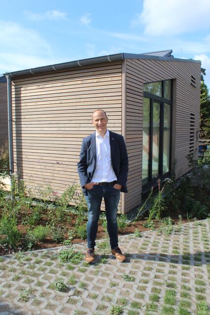 Dr. Christian Pape vor einem der Tiny-Häuser mit kleinem Beet | Foto: pm