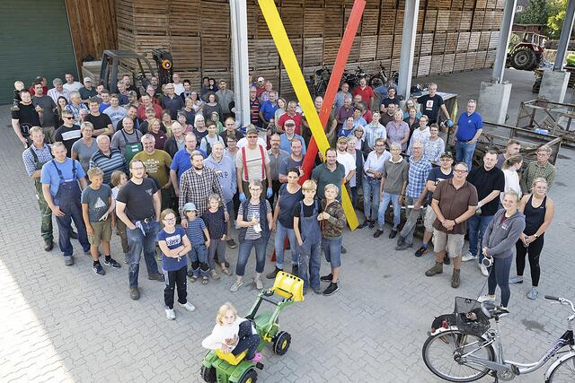 Geballter Protest: Rund 150 Einwohner der Gemeinde Toppenstedt trafen sich auf Einladung von Bürgermeister Stefan Isermann (lehnt mit grünem Polo-Shirt am Kreuz) zum Bauen von einem Dutzend gelb-roter Mahnkreuze | Foto: Antje Lohse