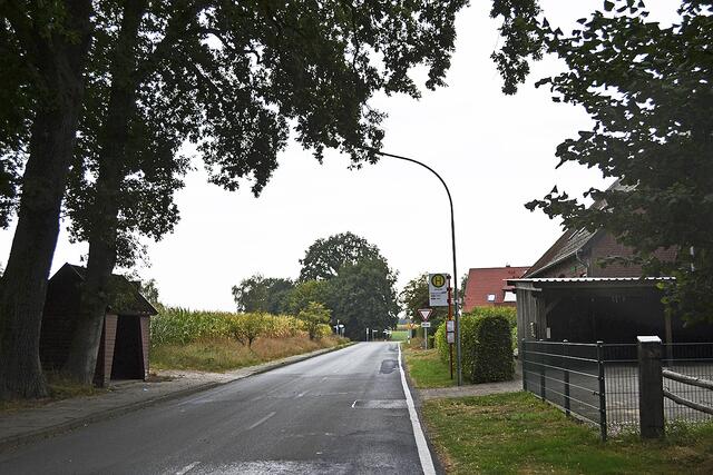 Die Bushaltestelle und die Wohnhäuser (re.) an der Dorfstraße sowie einige Häuser an der L141 gehören nach Versetzen des Ortsschildes nicht mehr zu Kampen | Foto: bim