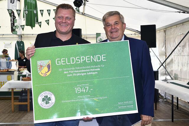 Bürgermeister Jürgen Ravens (re.) überreichte dem TSV-Vorsitzendem, seinem Sohn André Ravens, einen Scheck über 1.947 Euro | Foto: bim