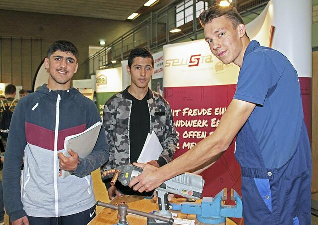 Mohammed Hasan (v.li.) und Mahmoud Alkadour ließen sich auf der Jobmesse 2019 von Louis Grave zeigen, wie man eine Wasserleitung baut | Foto: jab