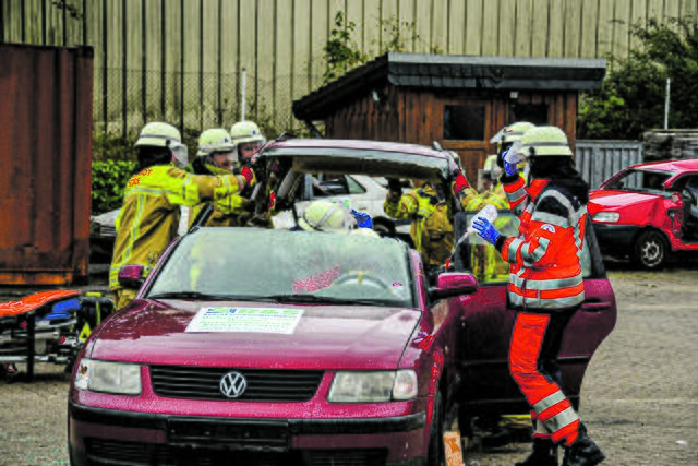 Die Feuerwehrkameraden heben das abgetrennte Dach vom verunfallten Wagen Fotos: sc