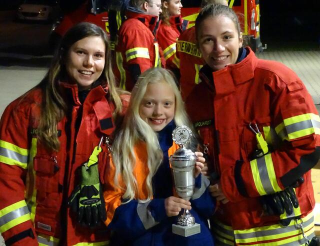 Einen Pokal für hervorragende Leistungen bekam Julina (11), ihre Betreuerinnen freuten sich mit ihr | Foto: Pressestelle Feuerwehr Samtgemeinde Hanstedt