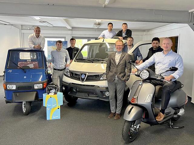 Die Piaggio-Experten von Kuhn+Witte (v.li.): Leon Krumm, 
Bennet Brunkhorst, Kevin Zlotkowski, Milad Osmani, Mike Westhäusler, Marcel Schmidt, Engin Arbursu und Matthias Müller mit Oliver Bohn (vorne links neben dem Piaggio-Roller stehend)  | Foto: Kuhn+Witte