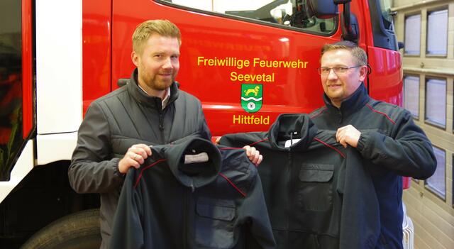 Praktisch und warm: Bennet Meier (li., Volksbank) und Simon Steffen zeigen die neuen Feuerwehr-Fleecejacken
 | Foto: A. Feldtmann/Feuerwehr Hittfeld