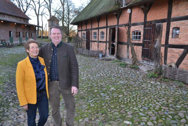 Die Gastgeber Sonja und Klaus-Detlef Kröger neben der denkmalgeschützten Fachwerkscheune von 1767 (re,) | Foto: bim