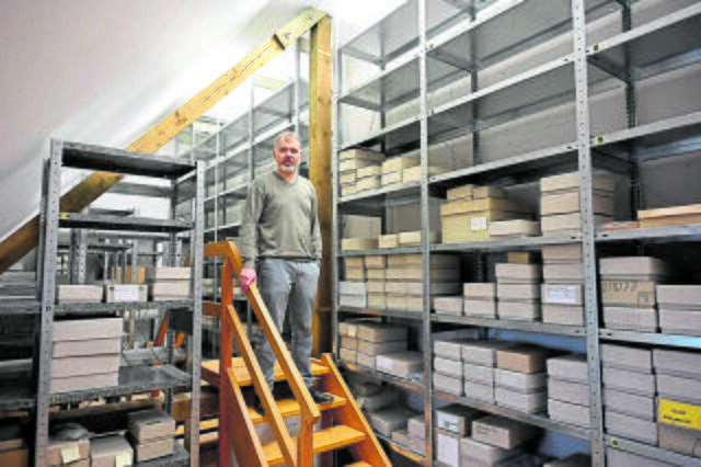 Die Kartons mit den Fundstücken stapeln sich bis zur Decke. Um an die obersten Regale zu gelangen, muss Daniel Nösler eine mobile Treppe nutzen.  | Foto: Daniel Beneke / LK Stade