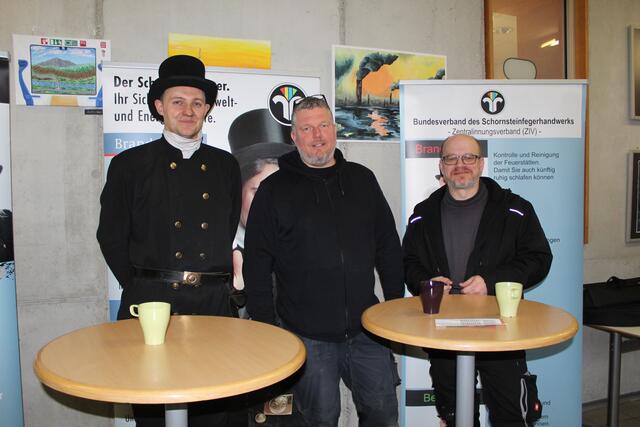 Die Schornsteinfeger Dennis Lohmann, (v.li.), Marcus Köhlmann und Karsten Möller werben auf der Messe für ihr Handwerk | Foto: pm