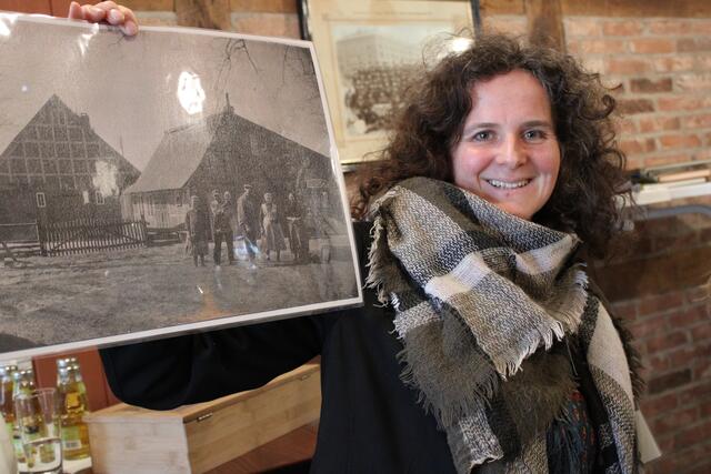 Annika Soltau erklärt das historische Foto der Stellmacherfamilie Peters vor ihrem Hof in Langenrehm | Foto: pöp