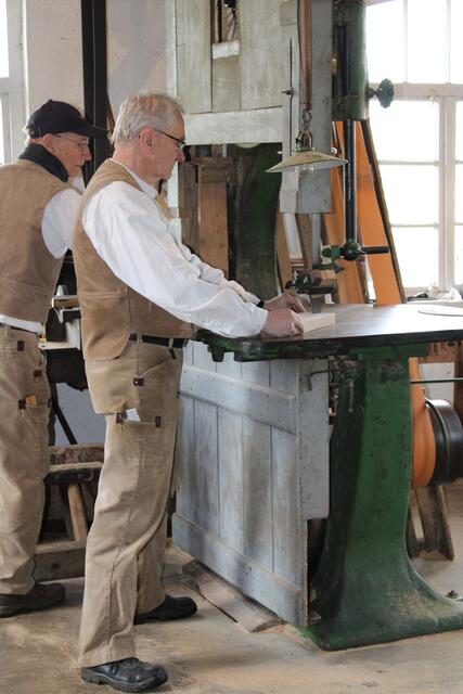 Alfred Scheurer sägt ein Teil aus, das vorher mittels einer Schablone auf den Holzblock gezeichnet wurde. Holger Bohnsack (hinten) assistiert | Foto: pöp