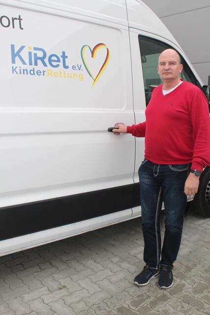 Mikel Zabel mit dem KiRet-Logo am Hilfstransport-Fahrzeug