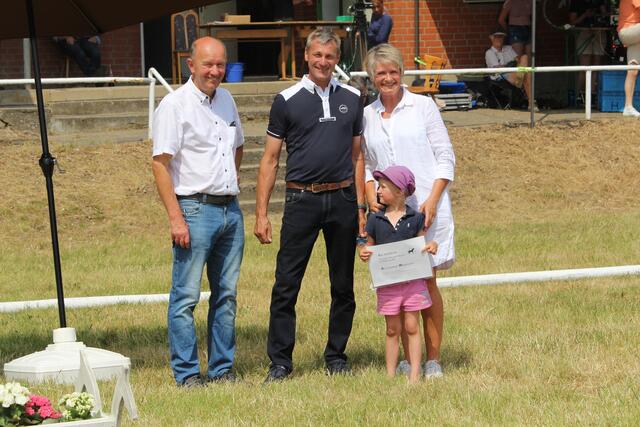 Die 4jährige Glücksfee Katelin Eggers aus Allermöhe hier bei der Tombolagewinnübergabe an Andreas Dittmer, Artlenburg (Mitte) neben PZV-Vorstand Herbert Vick vom Deichhof Tespe  (li) und dessen Ehefrau Anette Eberhardt (re) | Foto: Nicola Prüter