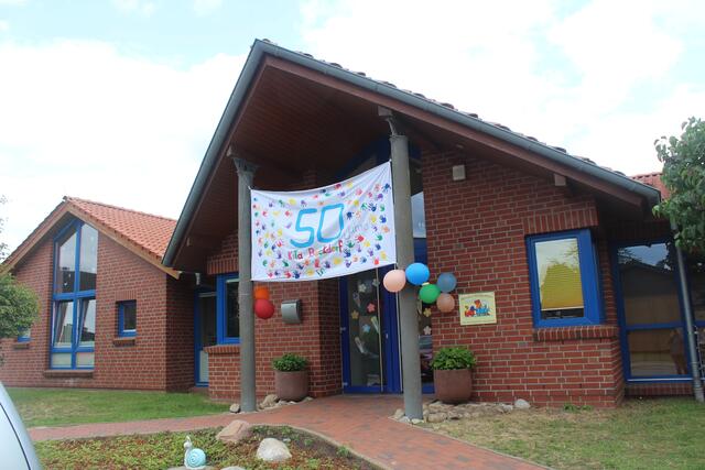 Mit einem großen Banner am Eingang machen Team und Kinder auf 50 Jahre Kita Beckdorf aufmerksam