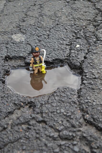 Dieser kleine Firefighter löscht kein Feuer: Er demonstriert, wie tief eines der Schlaglöcher in der Tostedter Zinnhütte ist  | Foto: bim