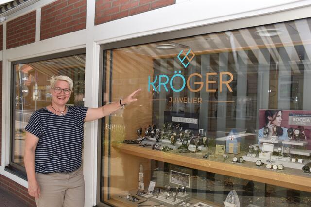 Inhaberin Katja Kröger weist auf das neue Logo von Juwelier Kröger hin