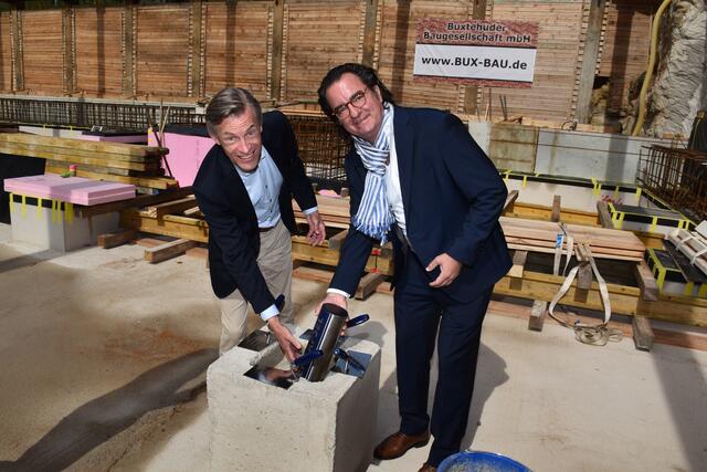 Die Zeitkapsel wird von Bürgermeister Jan-Hendrik Röhse und Andreas in den Schacht hineingelassen | Foto: Axel-Holger Haase