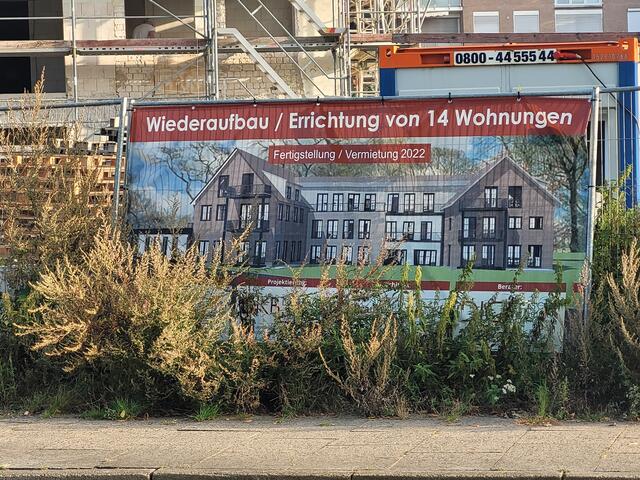 "Fertigstellung 2022": Die Aufschrift ist überholt. Hinter den Büschen kann man erkennen, wie das Haus mit 14 Wohnungen einmal aussehen soll | Foto: pöp