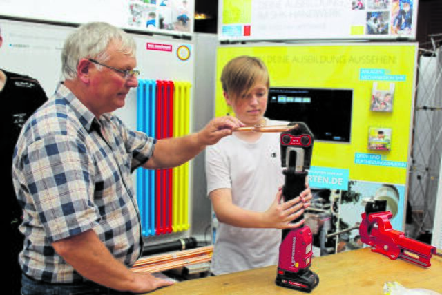 Mit Unterstützung des Handwerksmeisters Horst Vetter stellte Tim Kollberg (13) aus Oldendorf am Stand der SHK-Innung ein Herz aus Kupferrohr her | Foto: sb