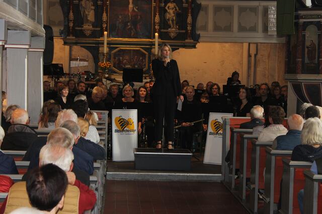 Dirigentin Raphaela Backhaus-Olbrich begrüßt das Konzertpublikum in der Kirche | Foto: ce