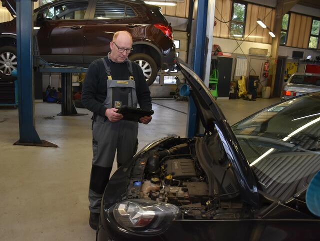 Hans Eickmann bei der Fehlerauslese mit dem Analysegerät bei einem Fahrzeug  | Foto: Axel-Holger Haase