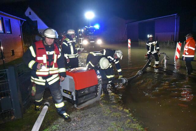 Feuerwehrleute pumpen das Wasser von der Straße "Am Osterbach" in Oelstorf | Foto: Mathias Wille
