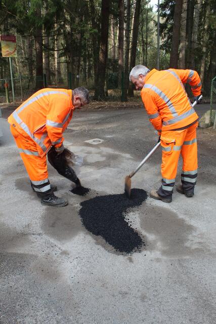 "Team Asphalt" Guido Kleen (li.) und Marcel Andres demonstrieren, wie ein Schlagloch auf einer asphaltierten Straße mit Kaltasphalt repariert wird | Foto: pm