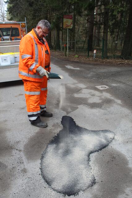 Guido Kleen demonstriert, wie ein Schlagloch auf einer asphaltierten Straße mit Kaltasphalt repariert wird | Foto: pm