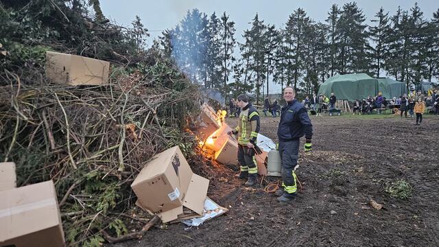 Ortsbrandmeister Christian Bertram (mit Gasflasche) zündete mit Unterstützung das Feuer an | Foto: Niklas Fink