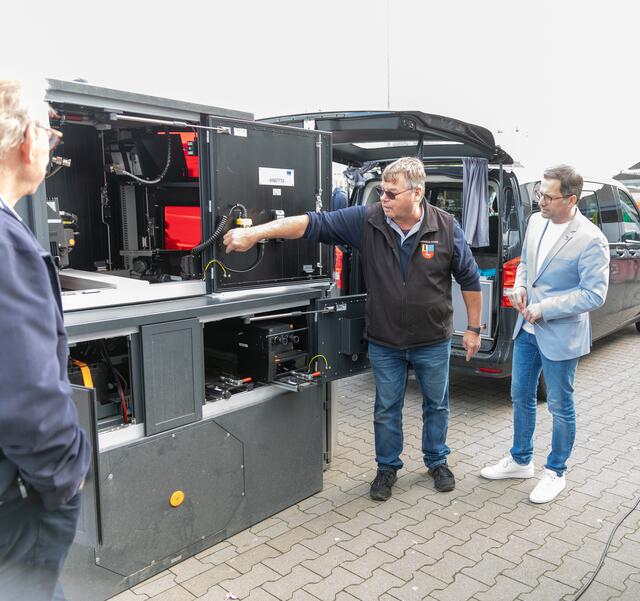 Landrat Kai Seefried im Gespräch mit Mitarbeitern der Straßenverkehrsbehörde, die den Besucherinnen und Besuchern des Verkehrssicherheitstages das Innenleben einer transportablen Anlage für Geschwindigkeitsmessungen erklärten. | Foto: Landkreis Stade/Christian Schmidt
