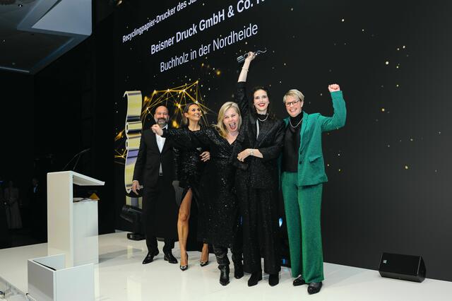 Zum ersten Mal in der BEISNER DRUCK GmbH &amp; Co. KG Recyclingpapier-Drucker des Jahres: Am 19. Oktober 2023 reisten unsere Kolleginnen Sabine Frommann, Myriam Wachsmann und Ineke Kamps nach Berlin. Die große Gala anlässlich der Awards findet seit vielen Jahren im Grand Hyatt am Potsdamer Platz statt. Nach einem tollen Empfang und einem Galadinner wurde es spannend und die Freude riesengroß, als uns die zauberhafte Laura Wontorra (2.v.l.) gemeinsam mit einem Vertreter der Firma Steinbeis Papier die Trophäe übergab.  | Foto: BEISNER DRUCK GmbH &amp; Co. KG // David Goltz