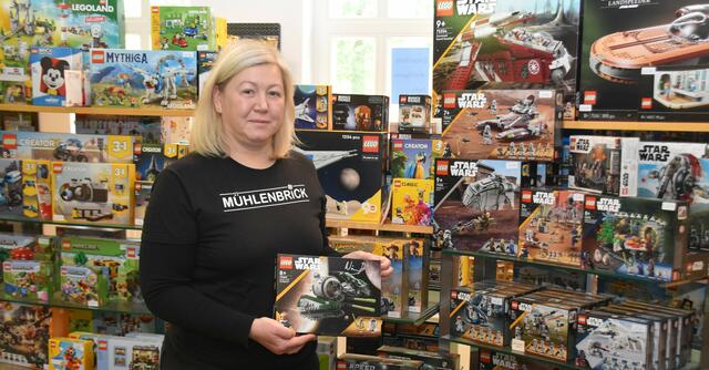 Jacqueline Müller-Dombrowski und ihr Ehemann Alexander Dombrowski weisen auf ihren LEGO-Laden hin | Foto: Axel-Holger Haase
