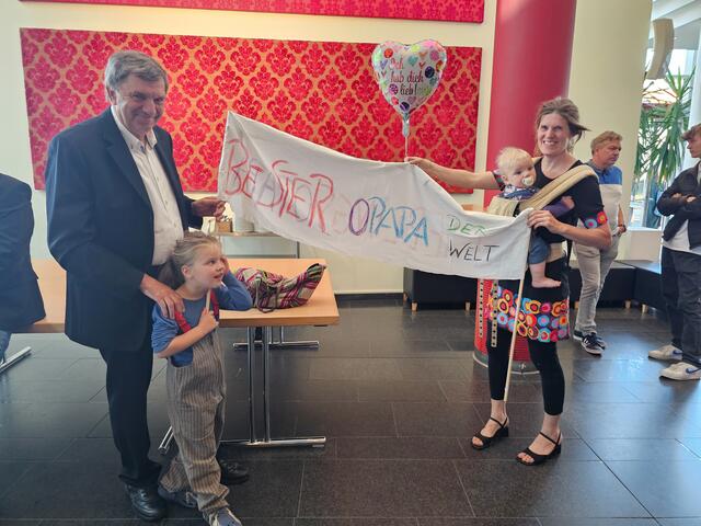 Ehrennadel-Träger Peter Becker wurde von seiner Tochter Katja Becker und seinen Enkelkindern Piet Joke (zehn Monate) und Ronja Lu (fünf Jahre) mit einem Banner „Bester Opa der Welt“ überrascht | Foto: Stadt Buchholz