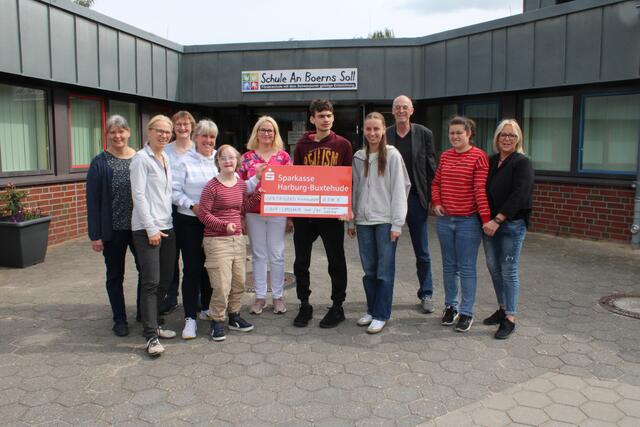 Bei der Übergabe des symbolischen Spendenschecks: Vertreterinnen und Vertreter der Förderschule An Boerns Soll und der Sparkasse Harburg-Buxtehude