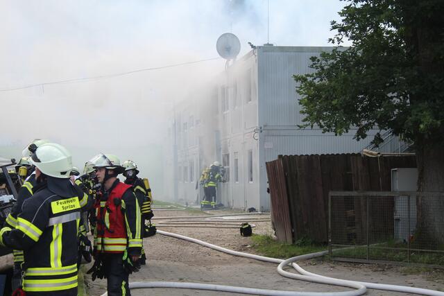 Die Feuerwehrkräfte beim Löschen der brennenden Container