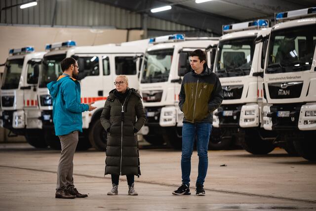 Mirko Temmler (Präsident NLBK, li.), Nadja Weippert (Landtagsabgeordnete) und Pascal Leddin (Landtagsabgeordneter) im Lager des NLBK vor Fahrzeugen des Katastrophenschutzes Niedersachsen | Foto: PL