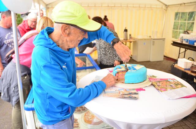 Arno Reglitzky (2. Vereinsvorsitzender) beim Anschneiden einer speziellen Blau-Weiss Buchholz-Torte | Foto: André Welle