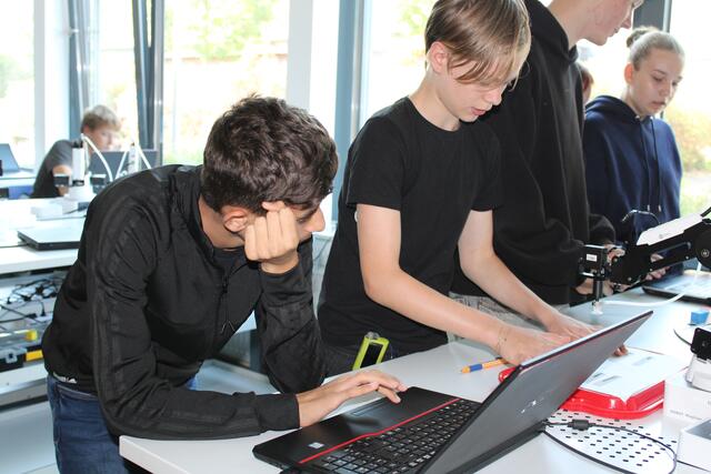 Rajab Almawas und Kjell Mundt wollen den Roboterarm (rechts) dazu bringen, Zettel richtig zu sortieren | Foto: pöp