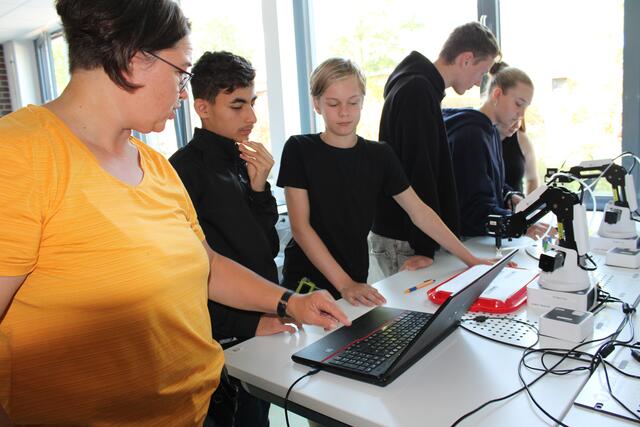 Warum macht der Roboter nicht genau das, war sich Rajab Almawas aus Bendestorf (14, 2. v. li.) und Kjell Mundt aus Jesteburg (13, 3. v. li.) wünschen? Lehrerin Kornelia Petersen erklärt es | Foto: pöp