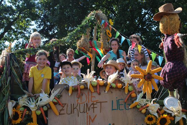 Nur die Vogelscheuche guckt griesgrämig. Mütter und Kinder hatten ihren Spaß auf dem Erntefestwagen | Foto: pöp
