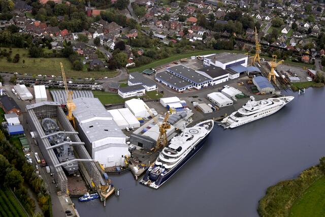 Dieses Foto dokumentiert die Bandbreite der renommierten Peters Werft. Die beiden Mega-Yachten "Al Mirqab" (li.) und "Pelorus" liegen am Kai der Werft. Im Dock befindet sich ein Tenderschiff der Marine | Foto: Peters Werft