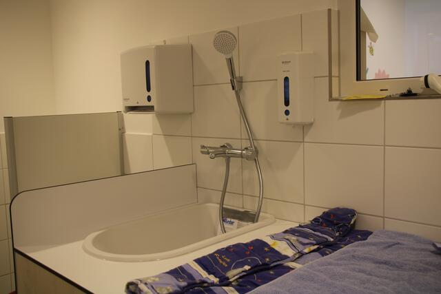Ein Wickelbereich, auf den die Kinder übrigens über eine kleine Treppe selbst hochklettern können, mit einer Badewanne  