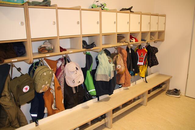 Gut durchdacht: Weil die Sitzbank etwas vorgezogen ist, können die Jacken dahinter am Haken und die Rücksäcke gut erreichbar davor aufgehängt werden. Die Garderoben wurden extra von einem Tischler angefertigt