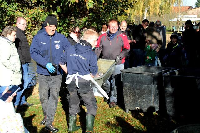 Mitglieder der Hoopter Feuerwehr bringen einen großen Karpfen zum bereitgestellten Becken | Foto: Burkhard Giese