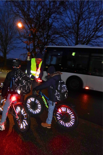 Vorbildlich unterwegs: Frank Patyna (Schulleitung Gymnasium Hittfeld) überreicht den beiden gut sichtbaren Schülern Leuchtarmbänder | Foto: Dilara Acar