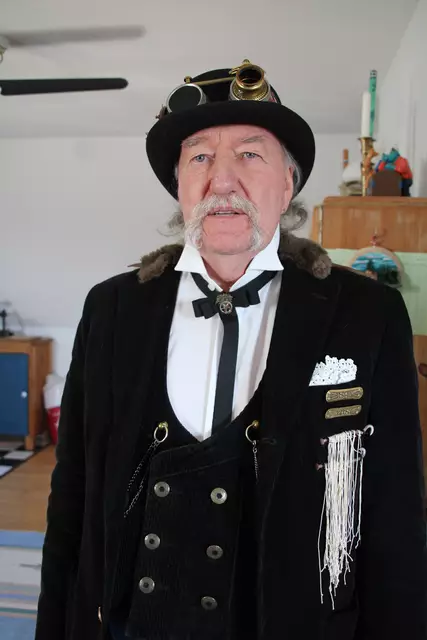 Die Kleidung ist die eines Fantasie-Kammerjägers - der Hut mit typischer Steampunkbrille verziert